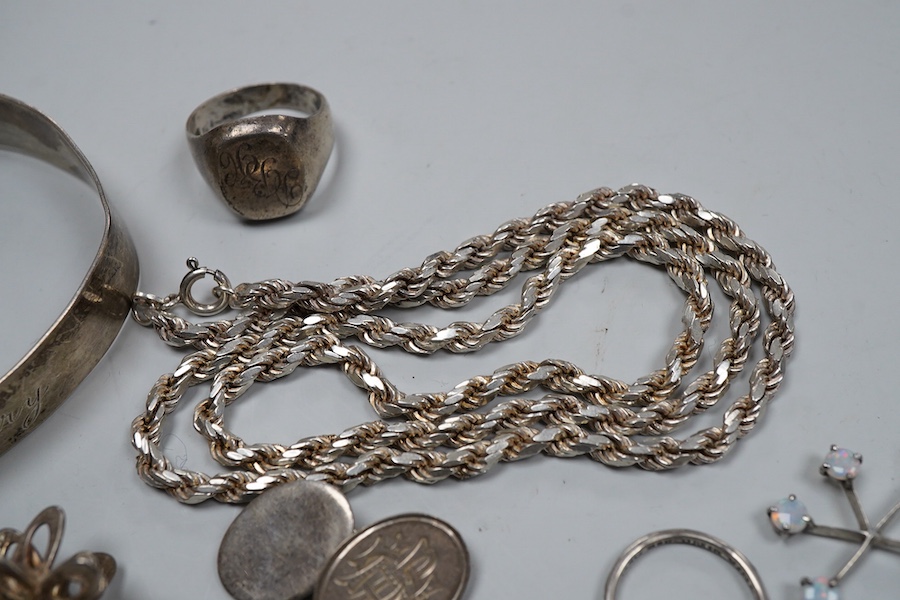 A collection of silver jewels, comprising: a bangle; a chain necklace suspending two winding toothpicks, one with toothpick deficient; a rope twist chain; a pair of cufflinks with the initials DBH; a pendant of abstract